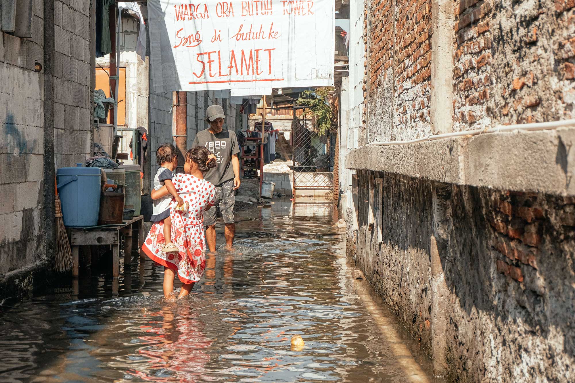A-banner-stretches-across-a-narrow-alley-as-residents-go-about-their-day_-“We-don’t-need-more-towers.-We-need-to-stay-alive.”-Photo-credit_-Kota-Kita_Angga-Bakti